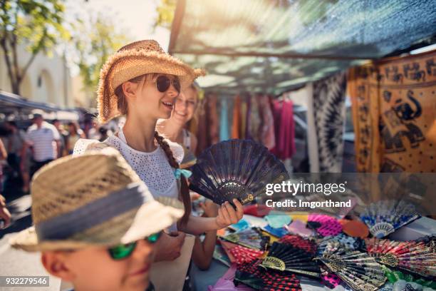 family buying souvenirs on flea market in andalusia, spain - costa del sol málaga province stock pictures, royalty-free photos & images