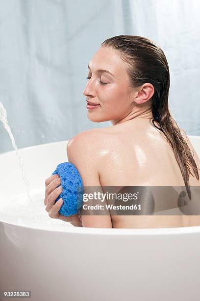 young woman sitting in bathtub, eyes closed, portrait - woman bath tub wet hair stock pictures, royalty-free photos & images