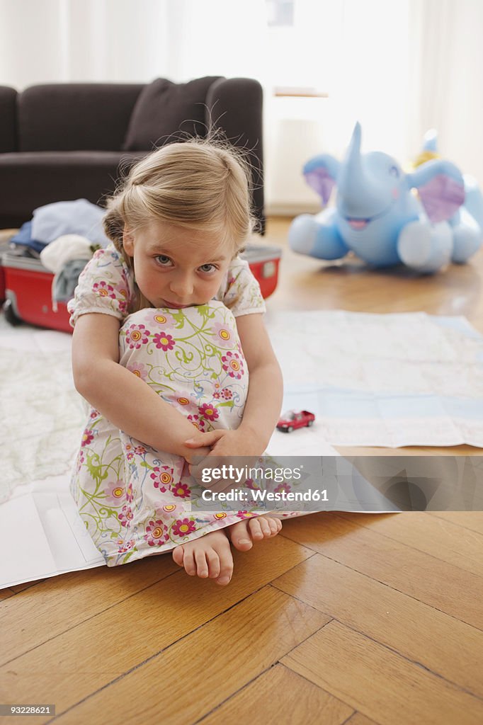 Germany, Leipzig, Girl (4-5) sitting on floor, portrait