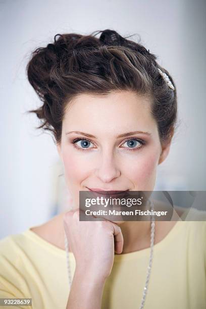 germany, young woman, hand to chin, close-up, portrait - mareen fischinger foto e immagini stock