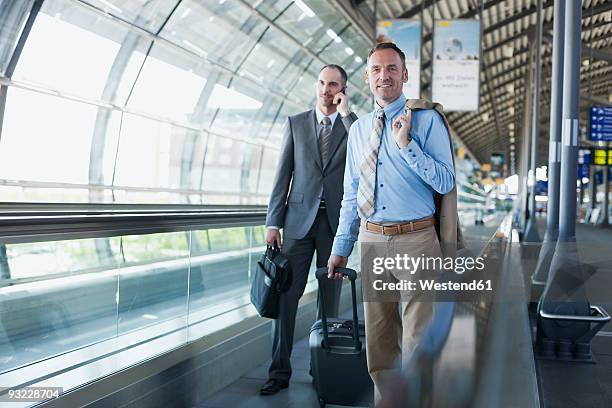 germany, leipzig-halle, airport, two business people on travelator - moving walkway airport stock pictures, royalty-free photos & images