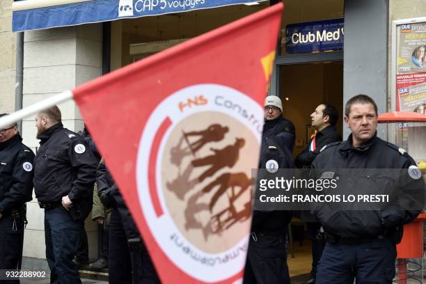 Police officers stand guard in front of the entrance of a store where French far-right Front National party's Member of Parliament for Valenciennes,...