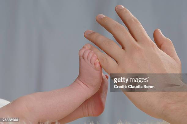germany, bavaria, munich, hand touching baby boy's feet (3 weeks), close up - first exposure series stock pictures, royalty-free photos & images