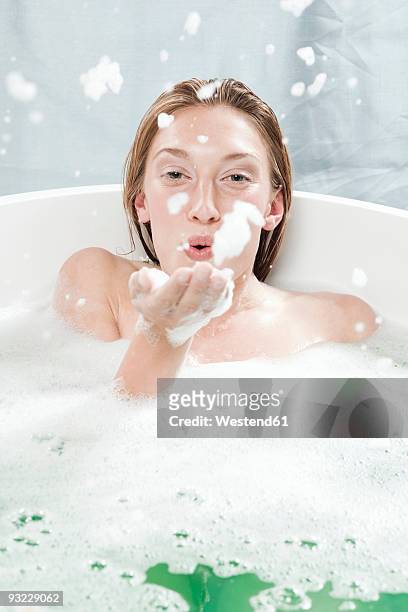 young woman in bathtub, fooling about - woman bath tub wet hair stock pictures, royalty-free photos & images