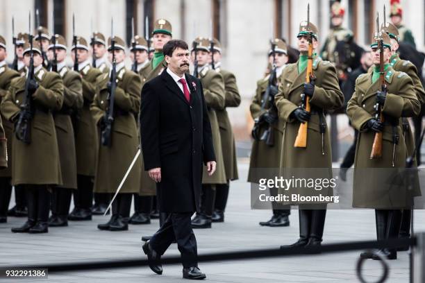 Janos Ader, Hungary's president, walks past honor guard soldiers standing in formation outside the Hungarian parliament building during a...