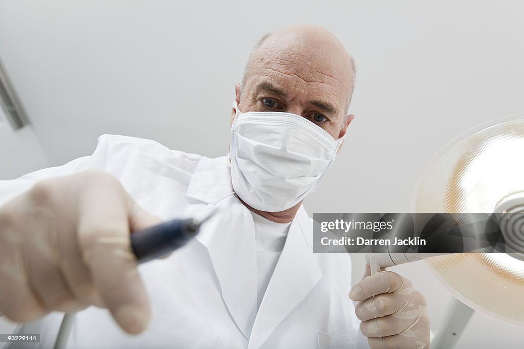 Germany, Bavaria, Landsberg, Dentist wearing mask holding medical equipment,