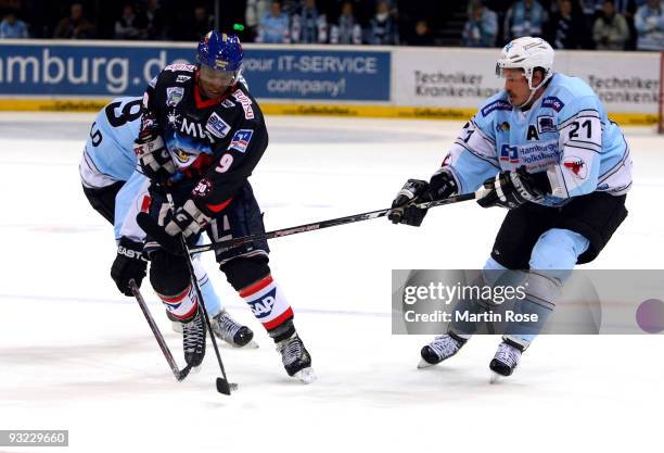 John Tripp of Hamburg and Nathan Robinson of Mannheim fight for the puck during the DEL match between Hamburg Freezers and Adler Mannheim at the...