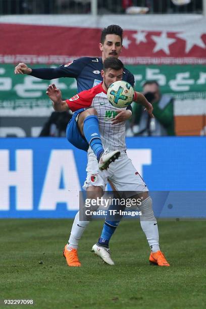 Benjamin Huebner of Hoffenheim and Marcel Heller of Augsburg battle for the ball during the Bundesliga match between FC Augsburg and TSG 1899...