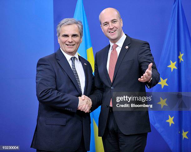 Werner Faymann, Austria's chancellor, left, arrives for the European Union Summit and is greeted by Fredrik Reinfeldt, Sweden's prime minister and...