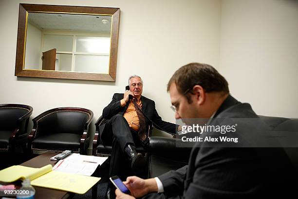 Chairman of the FreedomWorks and former U.S. House Majority Leader Dick Armey talks on the phone as he waits with his aide Adam Brandon in a holding...