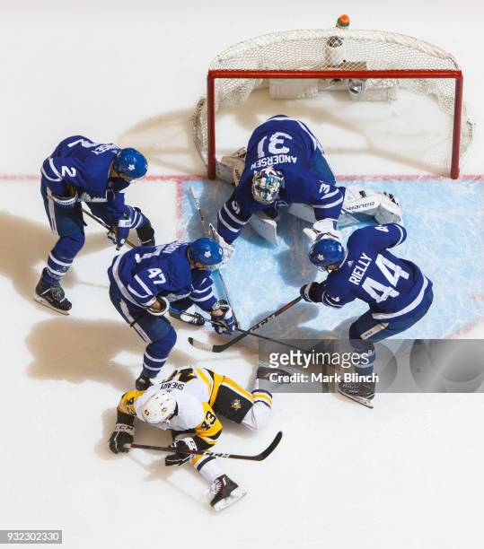 Frederik Andersen, Morgan Rielly, Leo Komarov and Ron Hainsey of the Toronto Maple Leafs protect the puck against Conor Sheary of the Pittsburgh...
