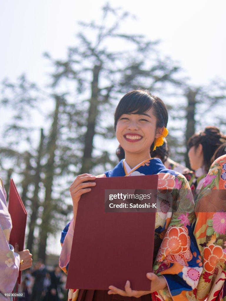 Mujer joven en hakama sonriendo después de la ceremonia de graduación
