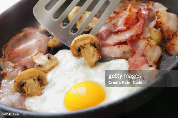 bacon egg and mushrooms cooking in frying pan - saturated fat stock pictures, royalty-free photos & images