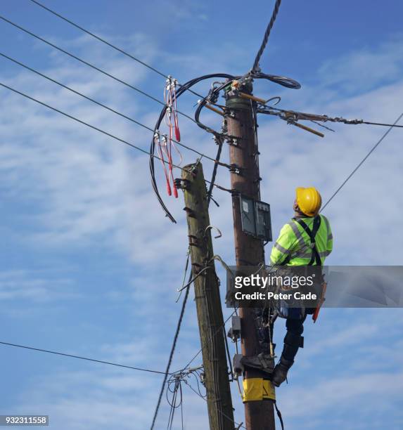 man up pole working on power lines - utility pole stock pictures, royalty-free photos & images