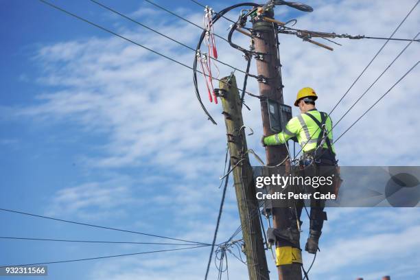 men up pole working on power lines - telecommunication stock-fotos und bilder