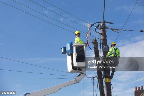 men up pole working on power lines - cable de conducción eléctrica fotografías e imágenes de stock