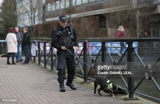 British police officer works with his sniffer dog in Salisbury, southern England, on March 15 as investigations and operations continue in connection...