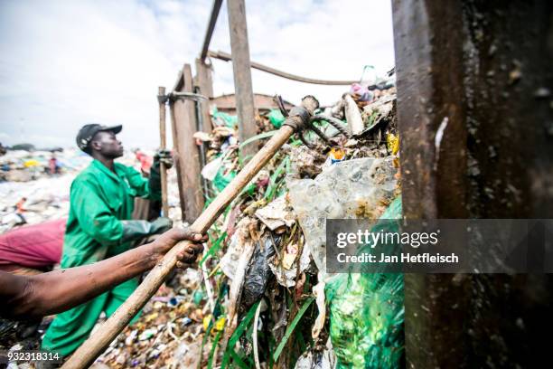 Men unload a truck at the Dandora rubbish dump on March 14, 2018 in Nairobi, Kenya. The Dandora landfield is located 8 Kilometer east of the city...