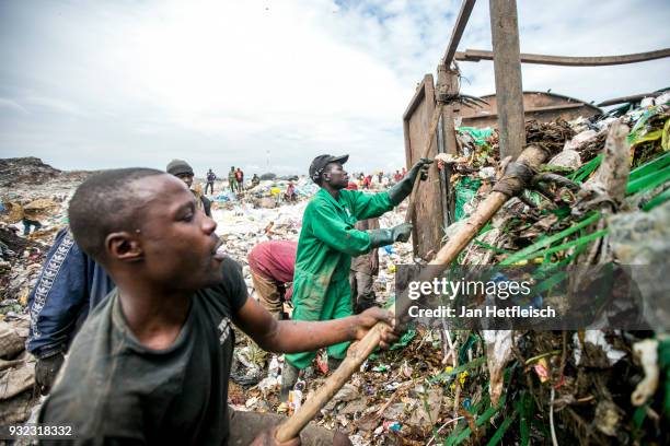 Men unload a truck at the Dandora rubbish dump on March 14, 2018 in Nairobi, Kenya. The Dandora landfield is located 8 Kilometer east of the city...