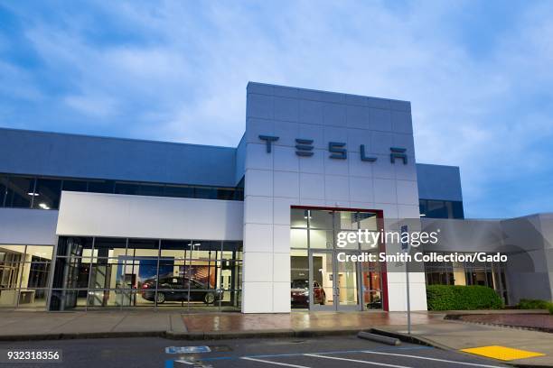 Facade with logo and sign at dusk at the Tesla Motors dealership in Pleasanton, California, March 12, 2018.