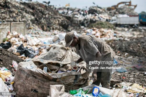 Man sorts out plastic bottles at the Dandora rubbish dump on March 14, 2018 in Nairobi, Kenya. The Dandora landfield is located 8 Kilometer east of...