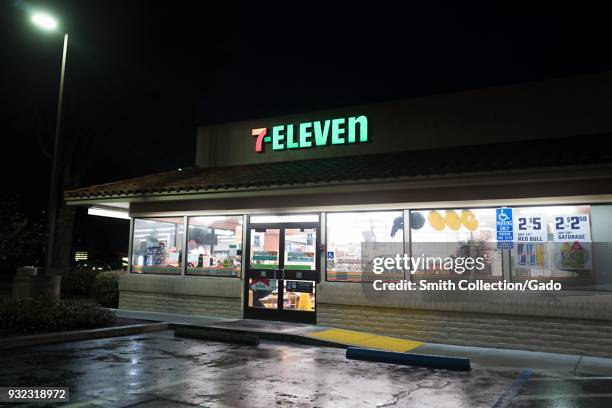 Night view of illuminated sign with logo and facade at 7-Eleven convenience store in Dublin, California, March 12, 2018.