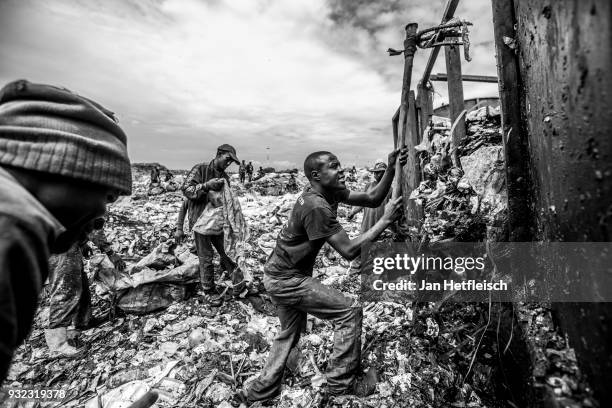 Men unload a truck at the Dandora rubbish dump on March 14, 2018 in Nairobi, Kenya. The Dandora landfield is located 8 Kilometer east of the city...