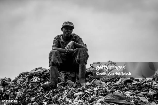 Man sits at the Dandora rubbish dump on March 14, 2018 in Nairobi, Kenya. The Dandora landfield is located 8 Kilometer east of the city center of...