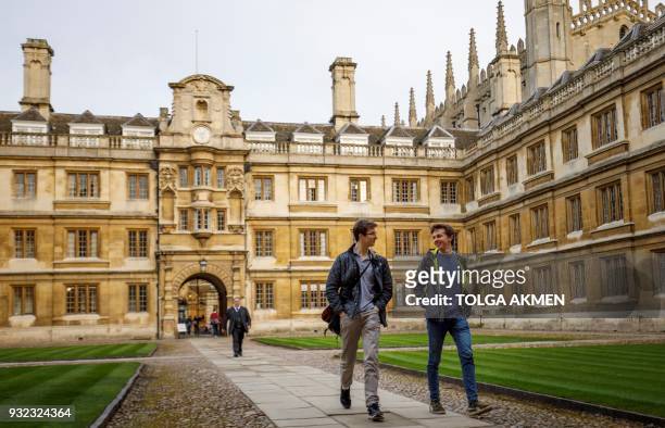 Students walk through Cambridge University in Cambridge, east of England, on March 14, 2018. / AFP PHOTO / Tolga Akmen