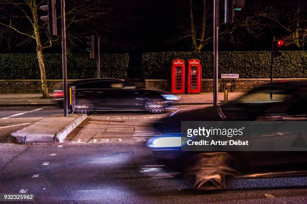 red twin telephone booths in the city of london close to hyde park. - car park barrier stock-fotos und bilder