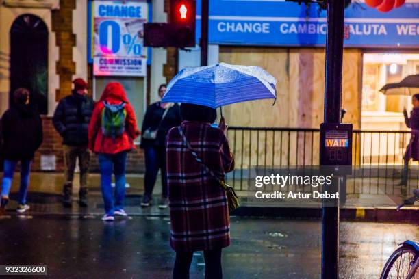 people in the streets of london with umbrella during rain in the night. - semáforo vermelho imagens e fotografias de stock