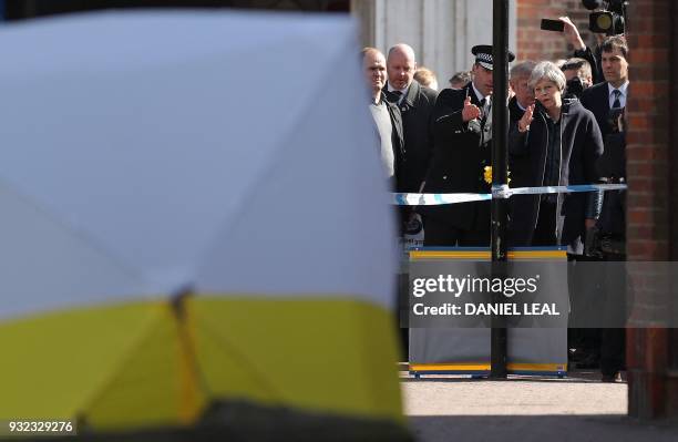 Britain's Prime Minister Theresa May talks with Wiltshire Police's Chief Constable Kier Pritchard as she is shown the police tent covering the bench...