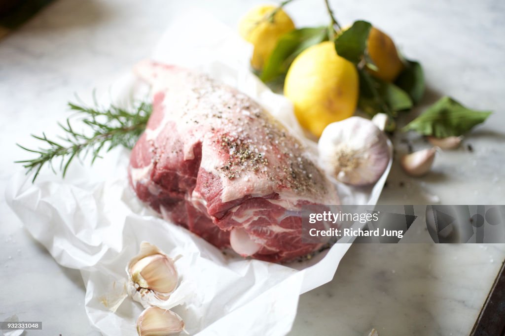 Fresh leg of lamb on white butcher paper still life.
