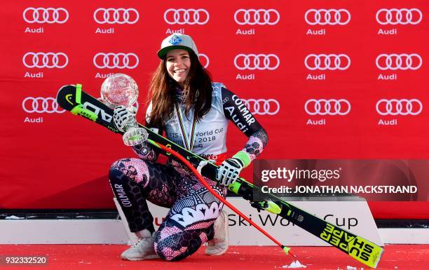 The women's overall season's Super-G winner Liechtenstein's Tina Weirather poses with her cristal globe on the podium after the FIS Downhill World...