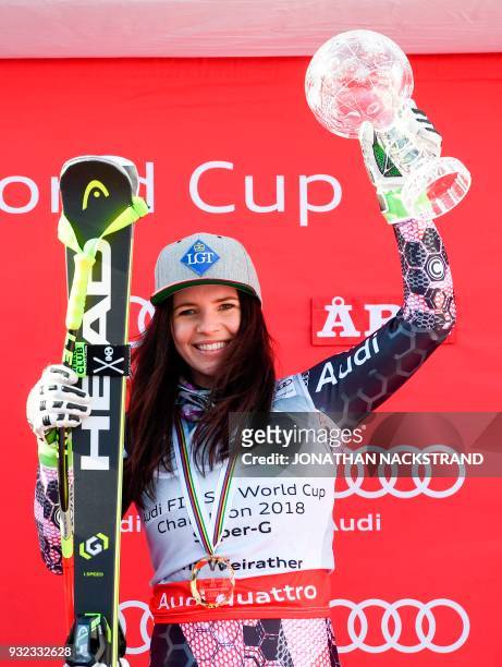 The women's overall season's Super-G winner Liechtenstein's Tina Weirather poses with her cristal globe on the podium after the FIS Downhill World...