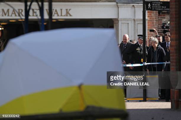 Britain's Prime Minister Theresa May talks with Wiltshire Police's Chief Constable Kier Pritchard as she is shown the police tent covering the bench...