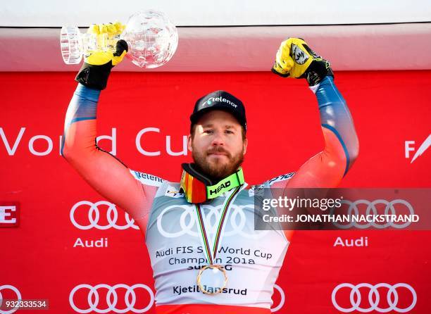 The men's overall season's Super-G winner Norway's Kjetil Jansrud poses with his cristal globe on the podium after the FIS Downhill World Cup final...