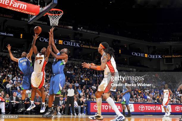 Kelenna Azubuike of the Golden State Warriors goes up for a shot against Wayne Ellington and Al Jefferson of the Minnesota Timberwolves during the...