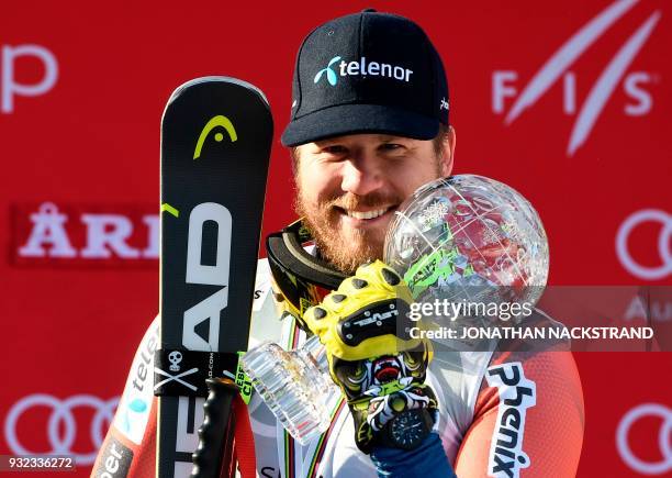 The men's overall season's Super-G winner Norway's Kjetil Jansrud poses with his cristal globe on the podium after the FIS Downhill World Cup final...