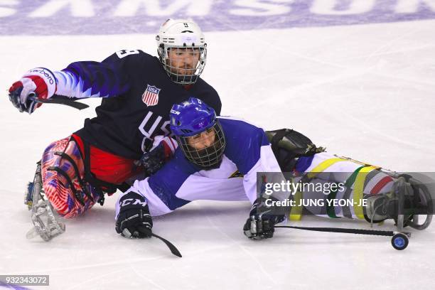 Travis Dodson of the US and Eusebiu Antochi of Italy fight for the puck in the ice hockey play-off semi-final game between the US and Italy at the...