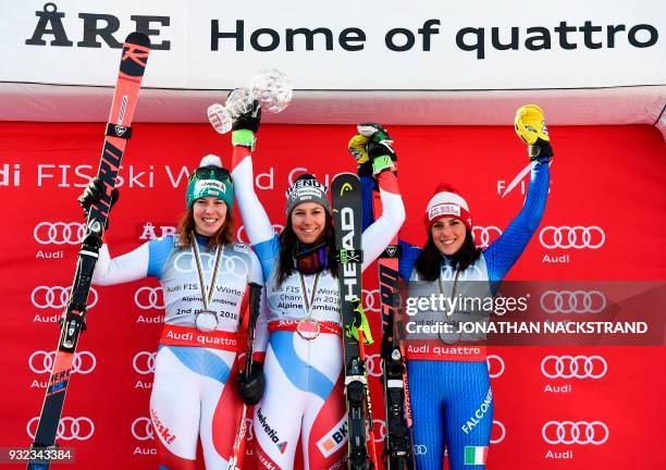 Second placed Switzerland's Michelle Gisin, overall winner Switzerland's Wendy Holdener and third Italy's Federica Brignone celebrate on the podium...