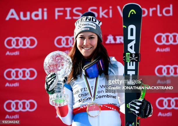 The overall winner Switzerland's Wendy Holdener celebrates on the podium of the women's overall season's alpine combined after the FIS Downhill World...