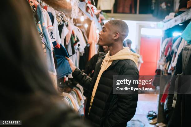 jóvenes adultos tienda de ropa en tienda - second hand fotografías e imágenes de stock