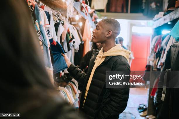 young adults shop for clothes at thrift store - thrift shopping stock pictures, royalty-free photos & images