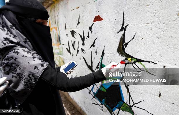 Yemeni artist paints graffiti on a wall during a campaign called 'Open Day of Art' in support of peace in the war-affected country, in the capital...