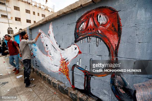 Yemeni artists paint graffiti on a wall during a campaign called 'Open Day of Art' in support of peace in the war-affected country, in the capital...