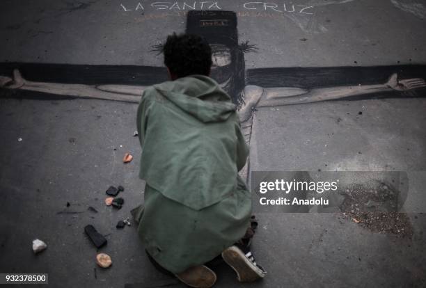 Homeless man draws a Jesus image on a sidewalk in Bogota, Colombia on March 10, 2018. People without roof involves regular heartbreaking scenes of...