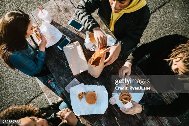 group of young adults eating fast food - fast food stock pictures, royalty-free photos & images