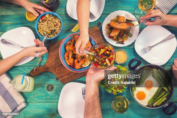 young family having lunch at home - eating seafood stock pictures, royalty-free photos & images