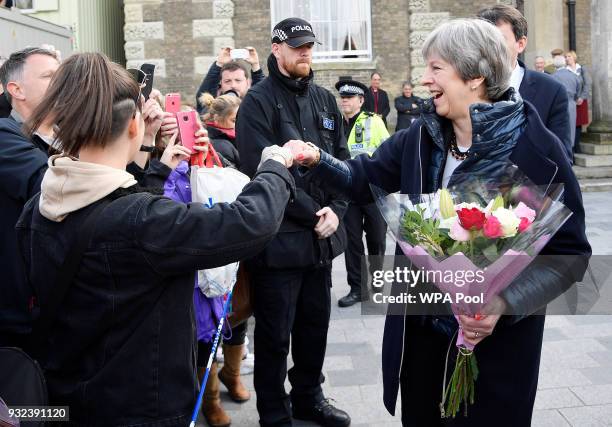 British Prime Minister Theresa May fist bumps a member of the public as she greets people after visiting the scene where former Russian intelligence...